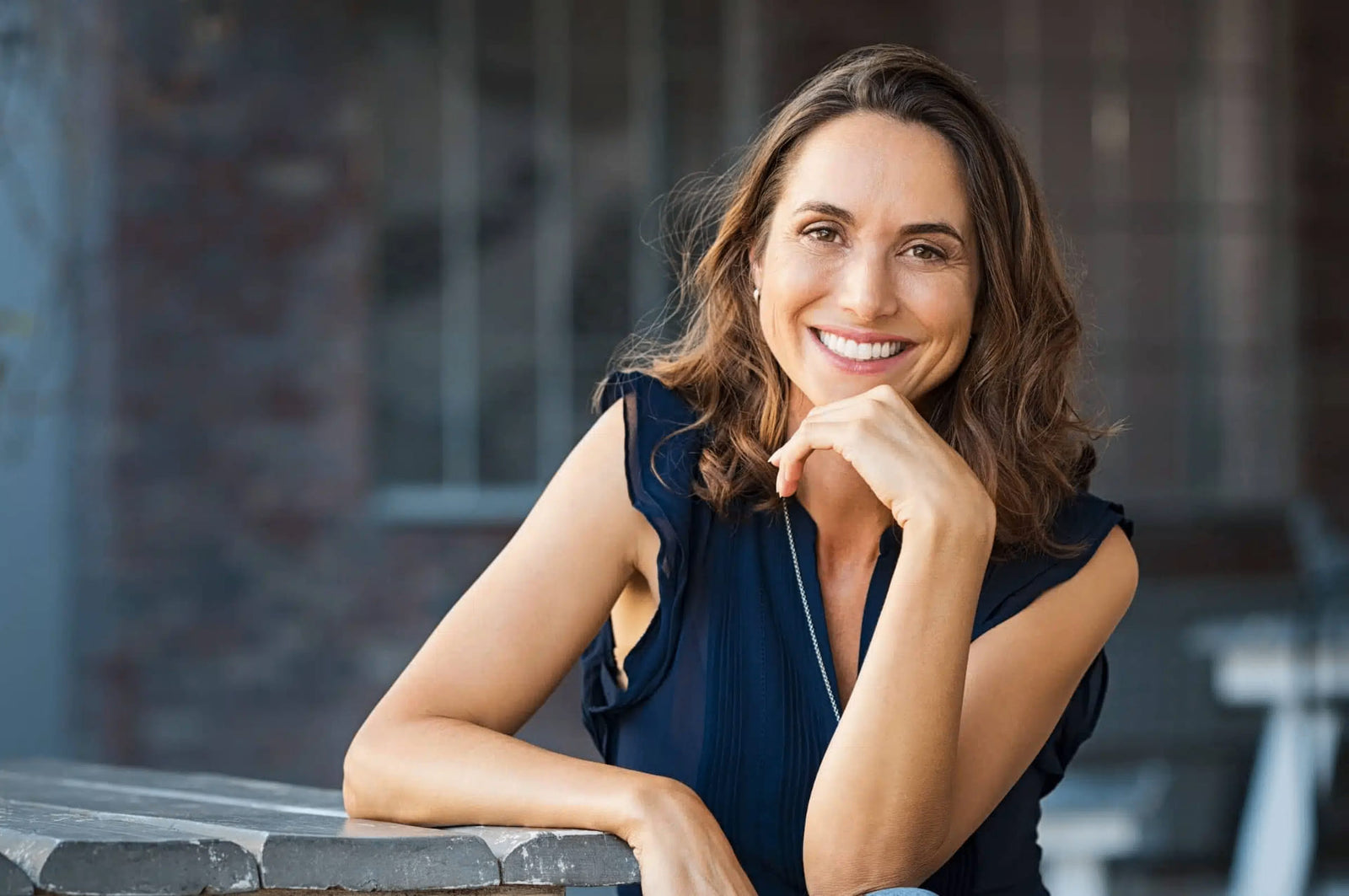 A warm, confident woman smiling thoughtfully.