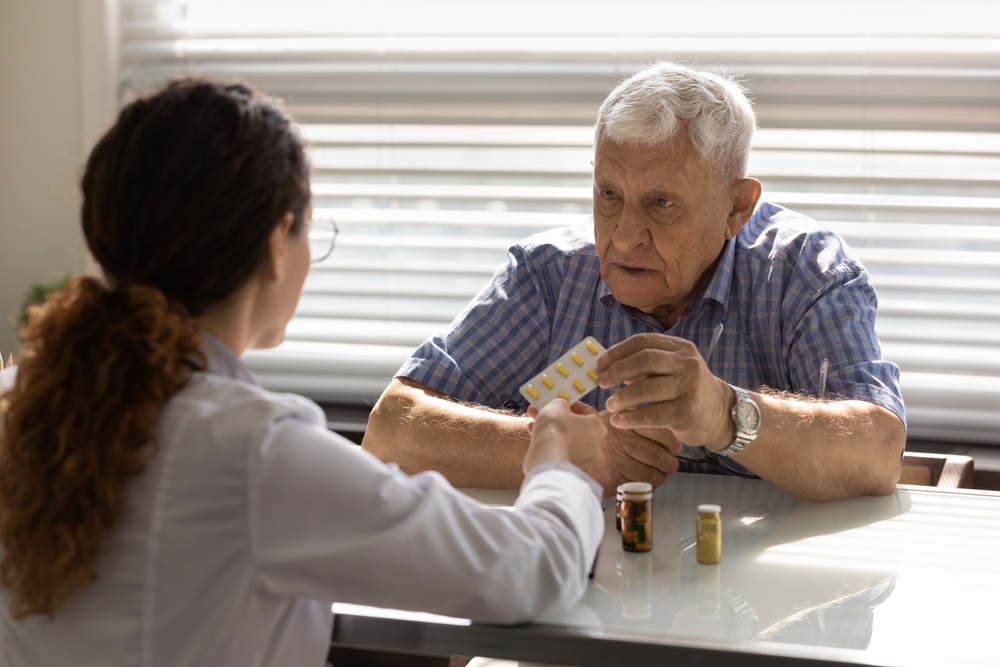 senior man asking pharmacist about medications