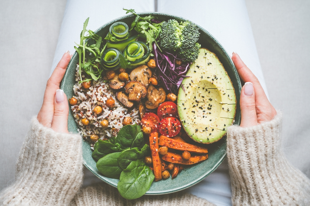 woman holding plate with vegetables and grains as healthy weight loss meal