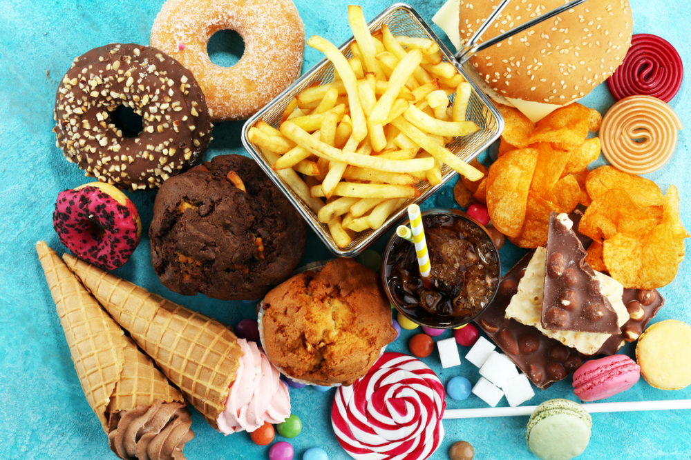 assortment of processed foods including chips,  sweets, fries, ice cream, soda