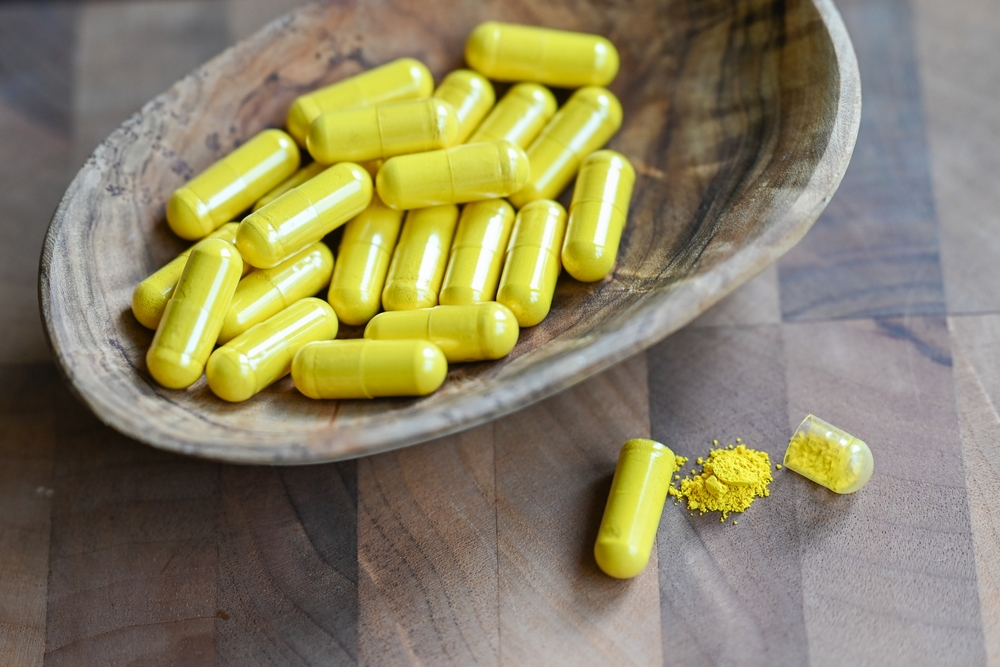 berberine capsules in wooden bowl